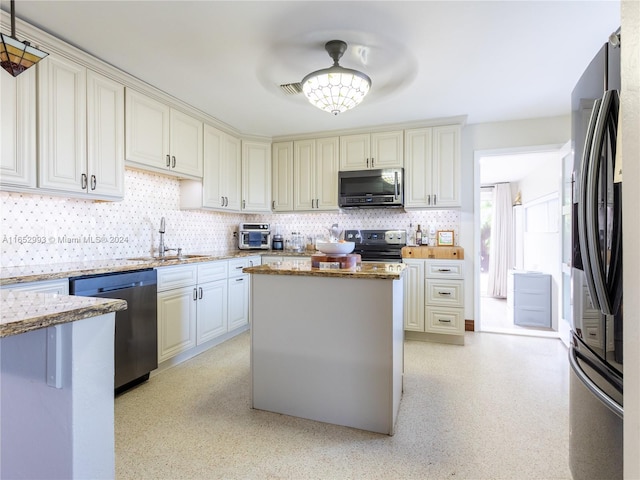 kitchen featuring a center island, sink, light stone countertops, and appliances with stainless steel finishes