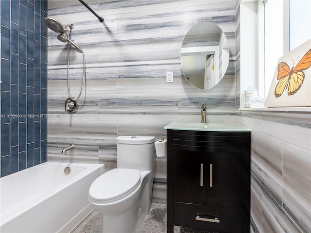 full bathroom featuring toilet, tile patterned flooring, vanity, tiled shower / bath combo, and tile walls