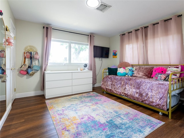 bedroom with dark hardwood / wood-style floors