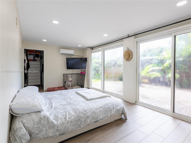 bedroom featuring access to exterior, a wall unit AC, and multiple windows