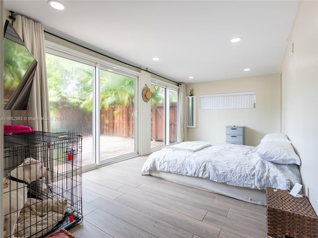 bedroom featuring wood-type flooring and access to outside