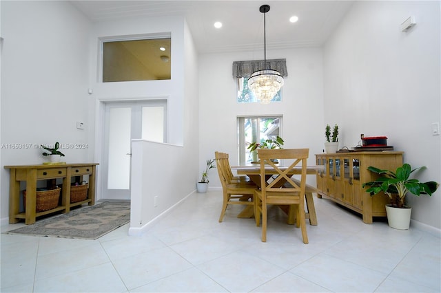 tiled dining room with high vaulted ceiling and an inviting chandelier