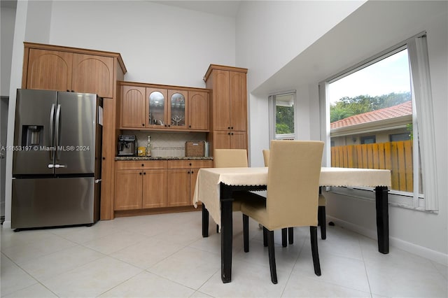 dining space with light tile patterned flooring and a high ceiling