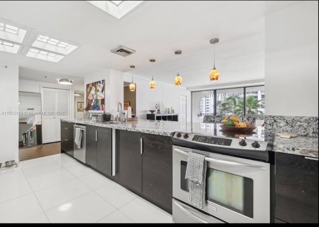 kitchen with a skylight, hanging light fixtures, stainless steel appliances, sink, and light tile patterned flooring