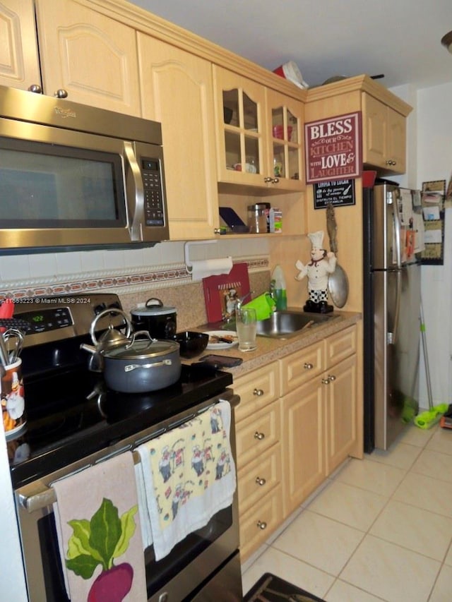 kitchen featuring stainless steel appliances, sink, light tile patterned floors, and light brown cabinets