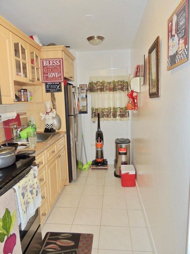 kitchen featuring light brown cabinetry, appliances with stainless steel finishes, and light tile patterned flooring