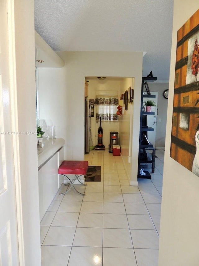 hallway featuring a textured ceiling and light tile patterned floors