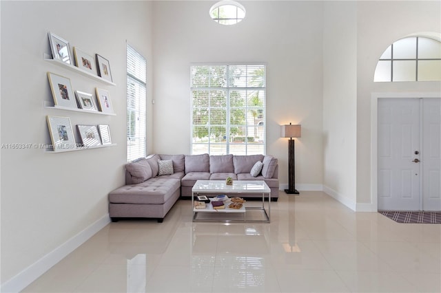 living room with a high ceiling and light tile patterned floors