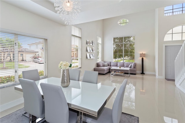 tiled dining space with a towering ceiling and a notable chandelier