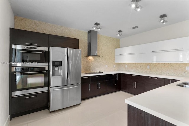 kitchen with white cabinets, tasteful backsplash, light tile patterned floors, wall chimney range hood, and stainless steel appliances