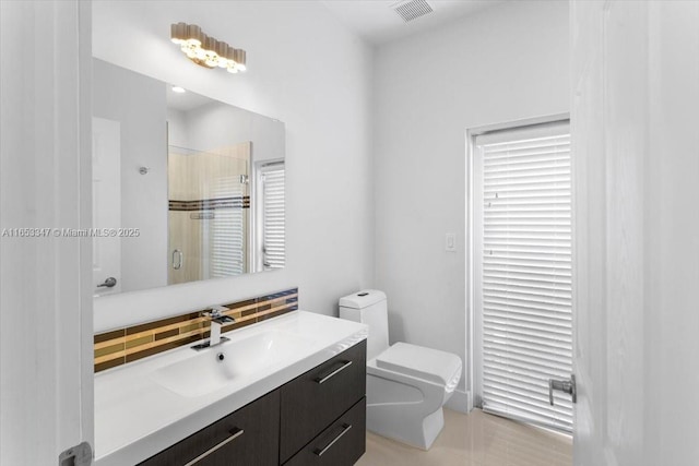 bathroom with toilet, walk in shower, a healthy amount of sunlight, and vanity