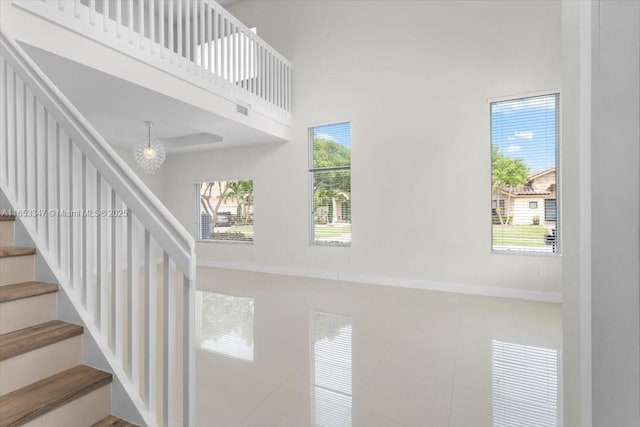 stairway featuring a high ceiling and tile patterned floors