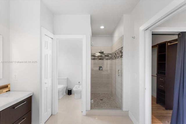 bathroom with a bidet, an enclosed shower, tile patterned floors, and vanity