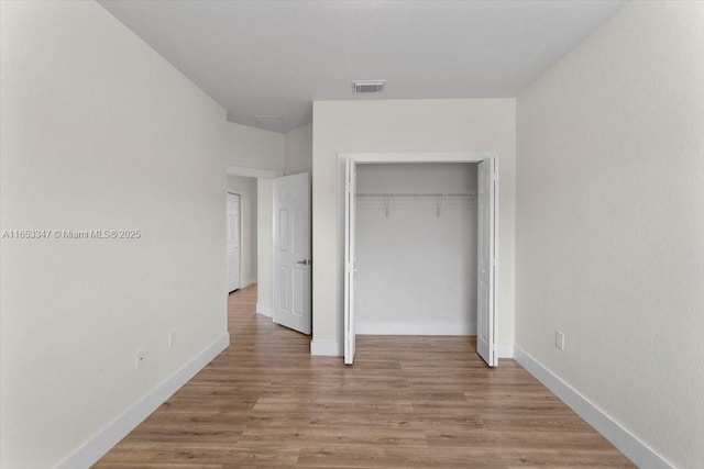 unfurnished bedroom with a closet and light wood-type flooring