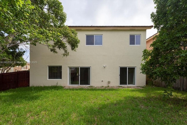 rear view of property with a lawn