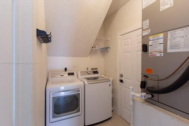 washroom with washer and clothes dryer, heating unit, and light tile patterned flooring