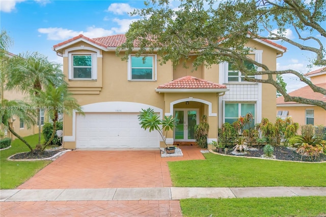 mediterranean / spanish home with a front yard and a garage