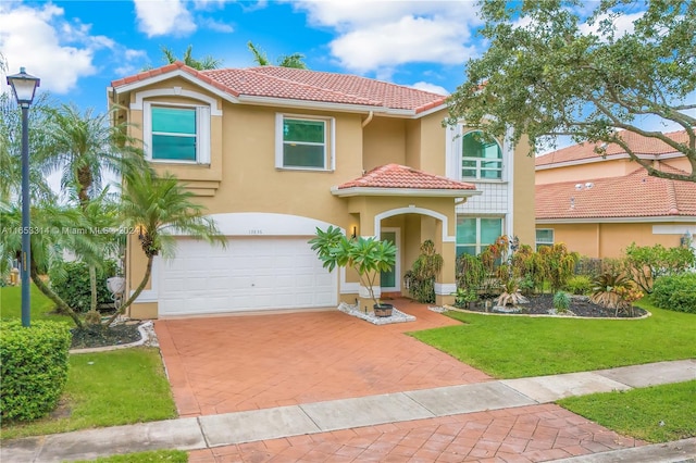 mediterranean / spanish home with a front lawn and a garage