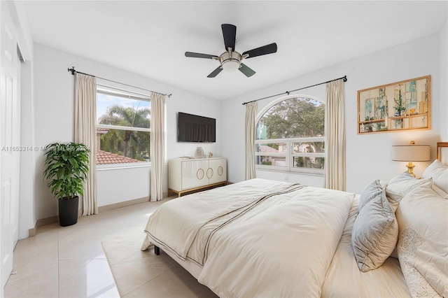 tiled bedroom featuring multiple windows and ceiling fan