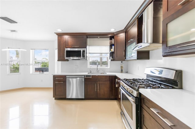 kitchen featuring appliances with stainless steel finishes, a wealth of natural light, hanging light fixtures, and sink