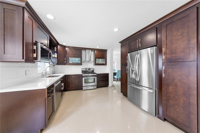 kitchen featuring wall chimney exhaust hood, sink, appliances with stainless steel finishes, dark brown cabinets, and light tile patterned floors