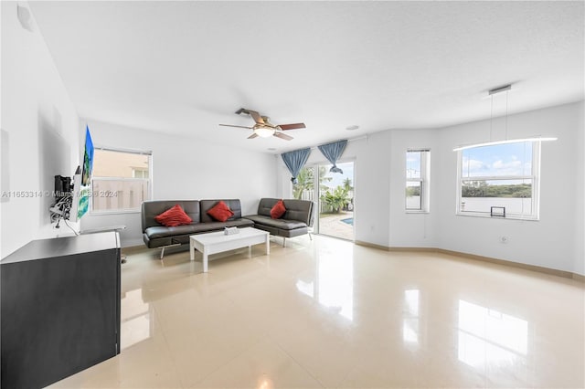 living room with a textured ceiling and ceiling fan