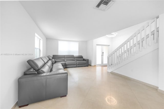 living room featuring french doors and light tile patterned floors