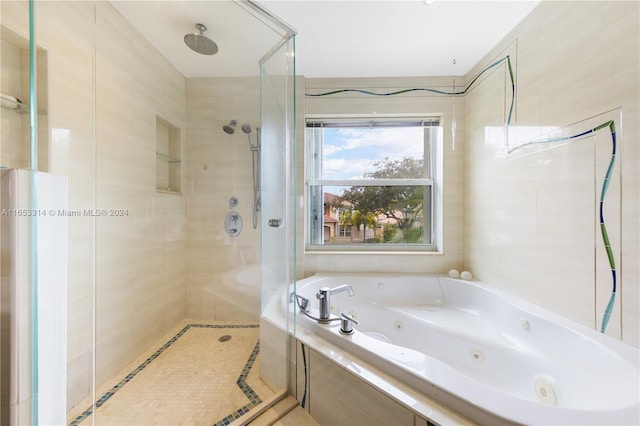 bathroom with separate shower and tub and tile walls