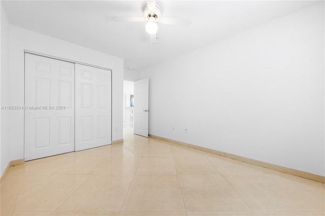 unfurnished bedroom with ceiling fan, light tile patterned flooring, and a closet