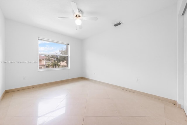 tiled empty room featuring ceiling fan