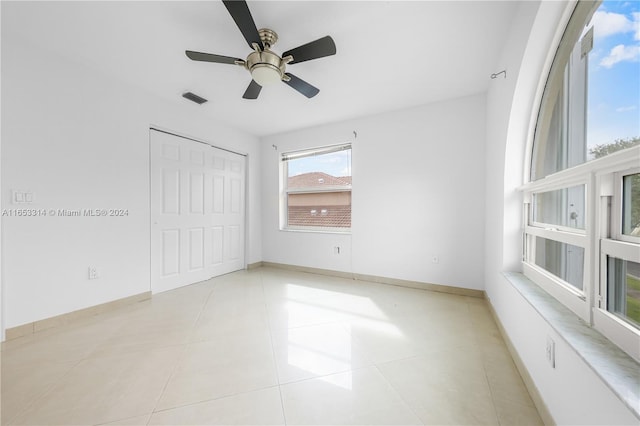 unfurnished bedroom with ceiling fan, a closet, and light tile patterned floors