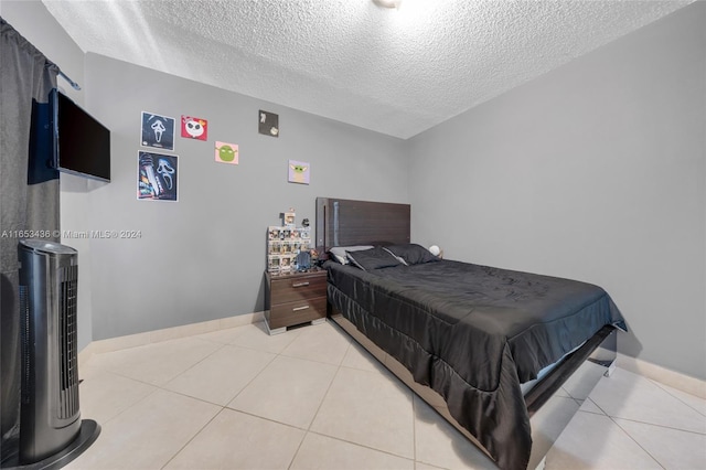 tiled bedroom featuring a textured ceiling