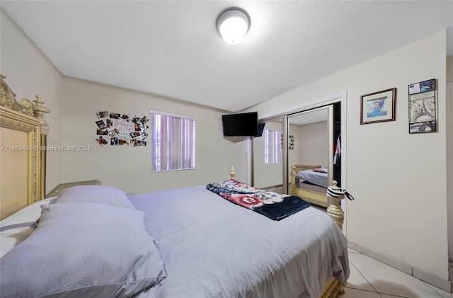 bedroom featuring light tile patterned floors and a closet