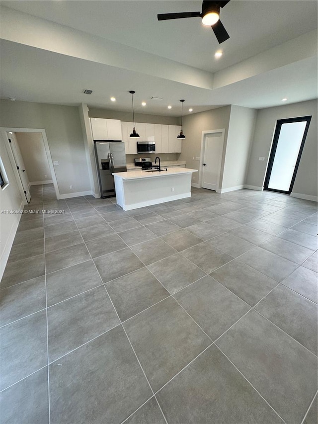 unfurnished room with ceiling fan, a raised ceiling, and tile patterned floors