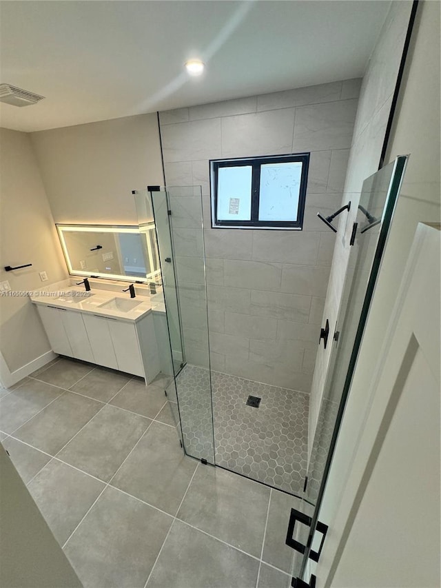 full bathroom with double vanity, tile patterned flooring, visible vents, and a walk in shower