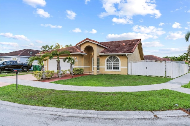 mediterranean / spanish house with a garage and a front lawn