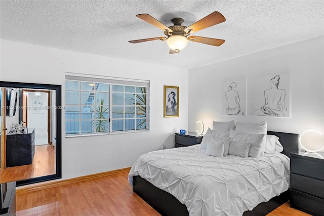 bedroom featuring a textured ceiling, light hardwood / wood-style flooring, and ceiling fan