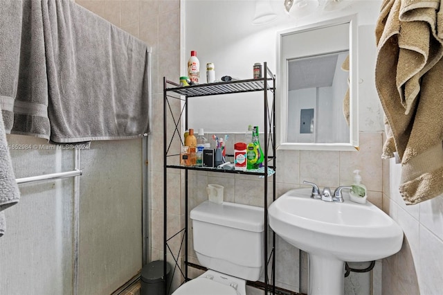 bathroom with an enclosed shower, tile walls, and toilet