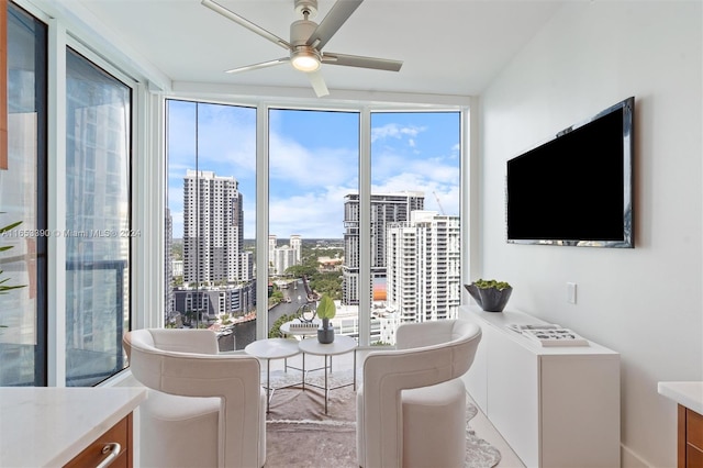 dining room featuring ceiling fan and a wall of windows