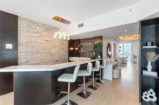 bar with pendant lighting and light wood-type flooring