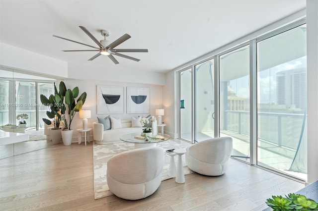 living room with light hardwood / wood-style floors, ceiling fan, and plenty of natural light