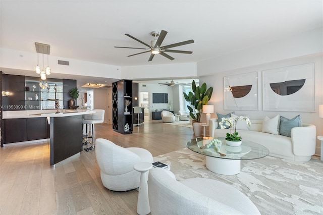 living room with light hardwood / wood-style flooring and ceiling fan