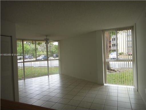 tiled spare room featuring ceiling fan