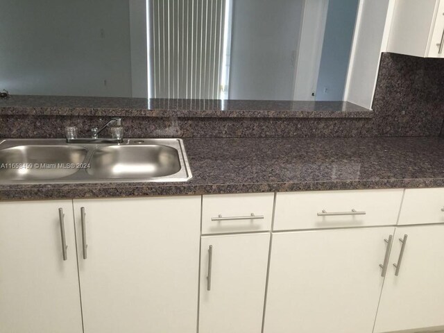 kitchen with sink, backsplash, and white cabinetry