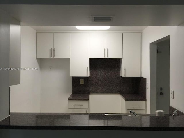 kitchen featuring white cabinetry and decorative backsplash