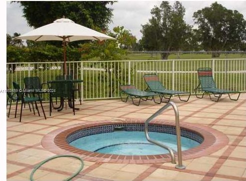 view of swimming pool with a hot tub