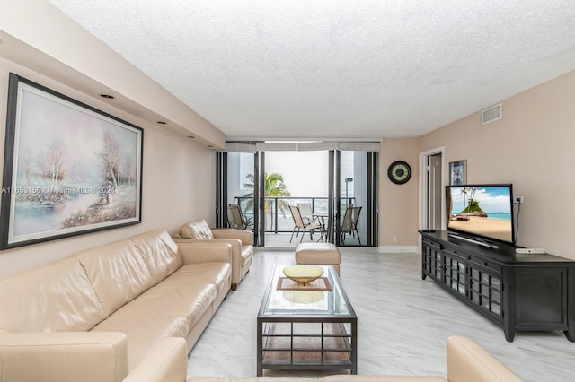 living room featuring a textured ceiling and floor to ceiling windows