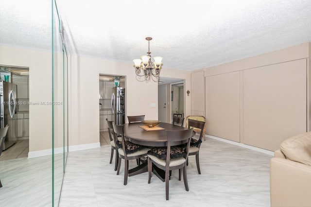 dining area with a chandelier and a textured ceiling