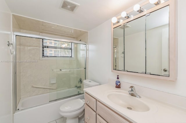 full bathroom featuring shower / bath combination with glass door, vanity, toilet, and tile patterned flooring