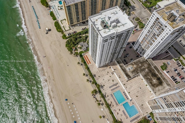 birds eye view of property with a water view and a beach view